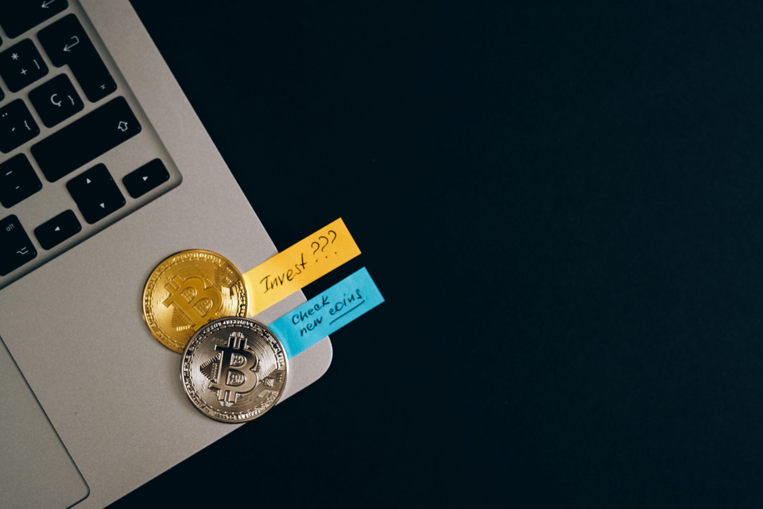 Bitcoins on laptop keyboard with sticky notes