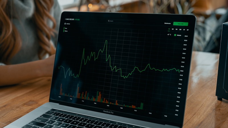 Laptop showing trading chart on desk